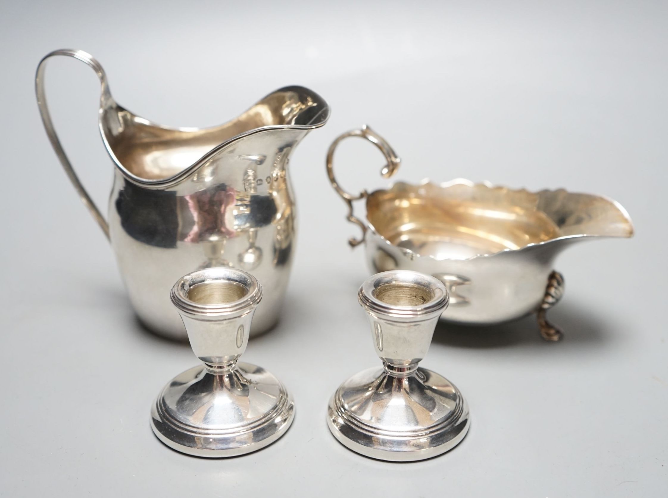 A George III silver jug, London, 1798, a silver sauce boat and pair of silver mounted dwarf candlesticks.